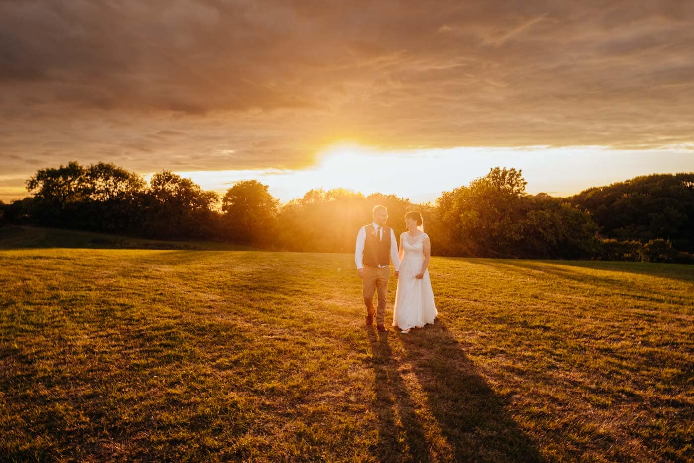 married couple walking with sunset background